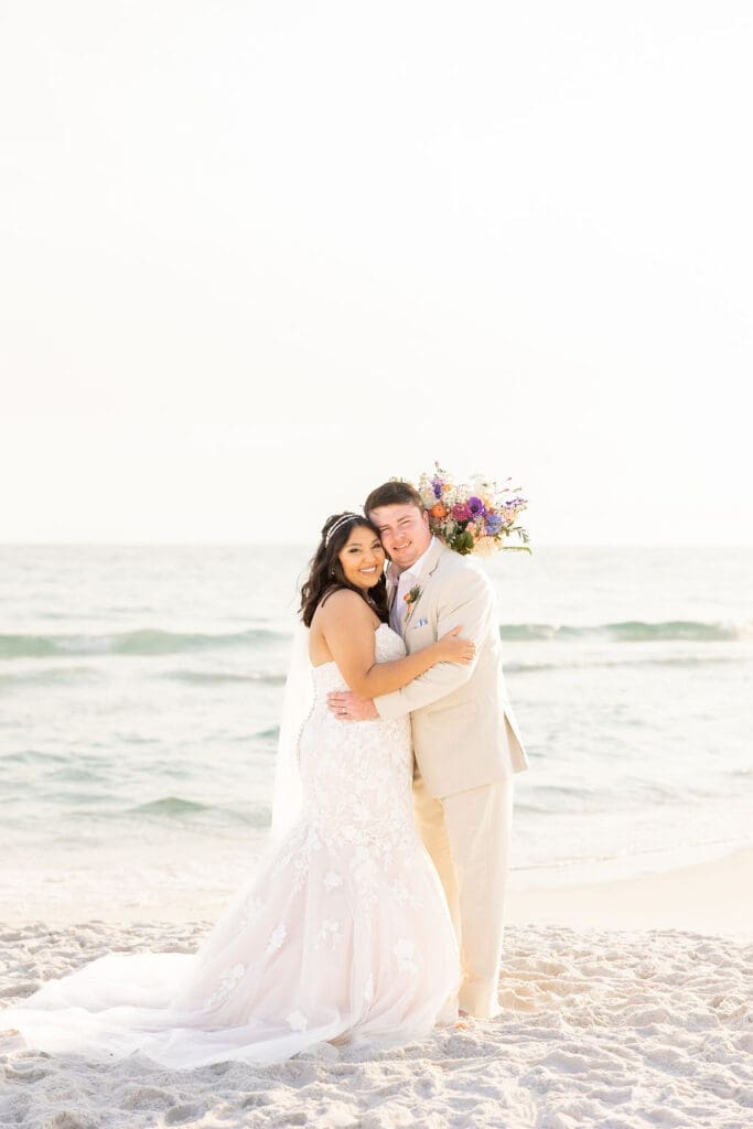 Bride and groom posing for a happy photo after wedding ceremony on a beach | Madison Abernathy Photography