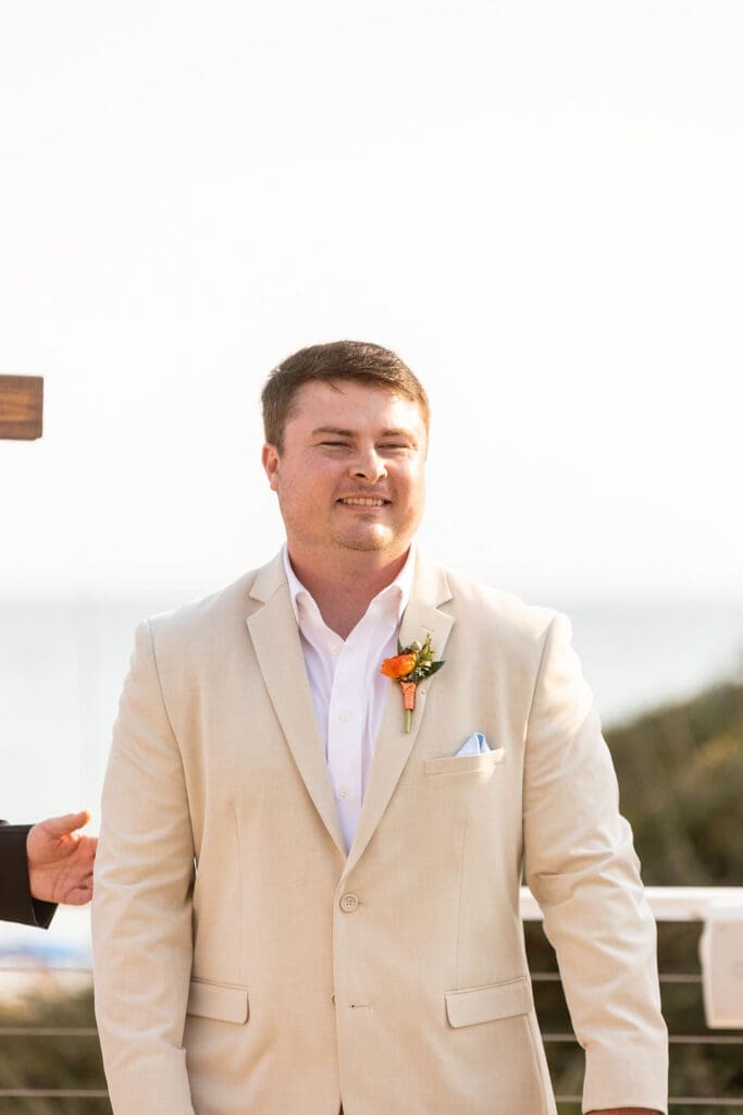 Groom looking at bride walking down the aisle at their beach wedding | Madison Abernathy Photography