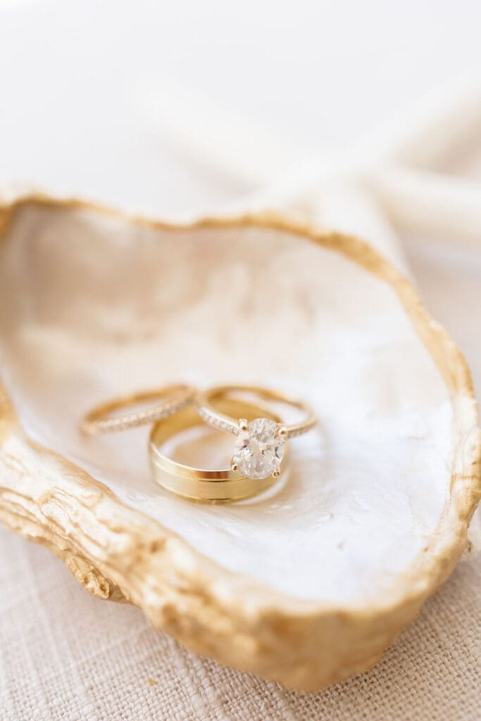Bride and groom's rings sitting in a seashell to represent beachside wedding | Madison Abernathy Photography