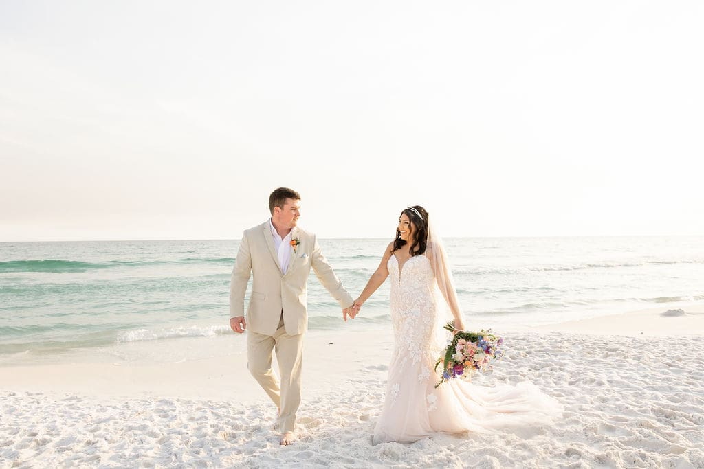 Bride and groom walking side by side down florida beach | Madison Abernathy Photography