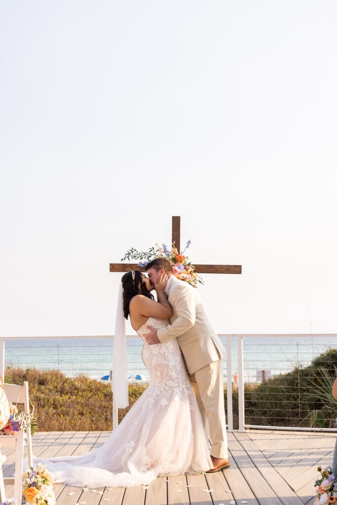 Groom dips bride into romantic kiss at beachside wedding | Madison Abernathy Photography