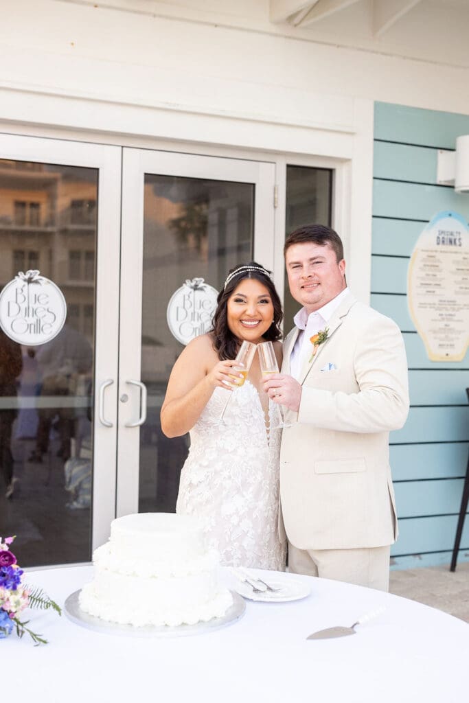 Bride and groom cut the cake and share champagne at vintage luxury beachside wedding in Destin, Florida | Madison Abernathy Photography